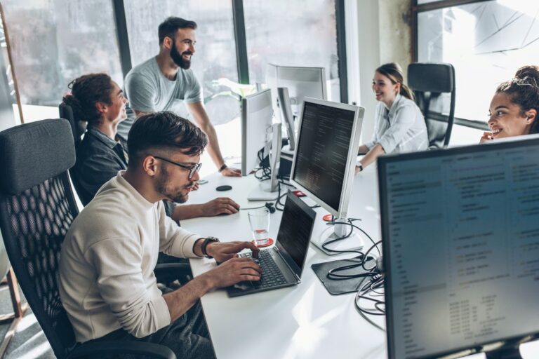 IT professionals collaborating in a modern Polish office environment, working together on software development projects